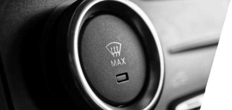 Black and white close-up of a car defroster control dial with max setting